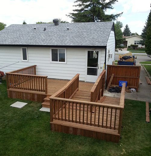 An overlooking view of a backyard wooden deck addition project