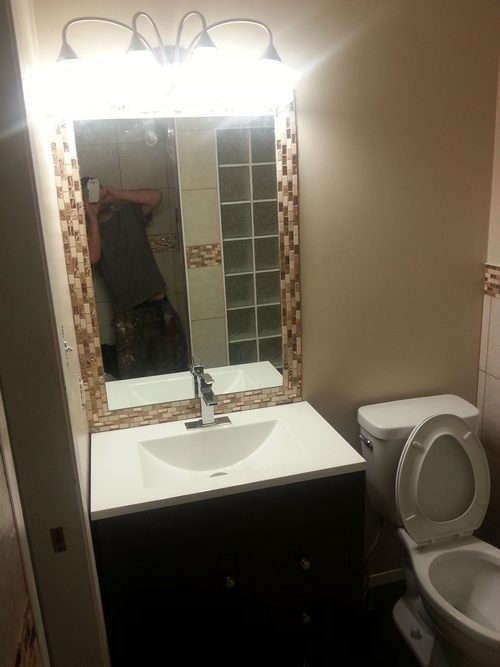 A tiled mirror frame and a modern sink for a bathroom renovation project