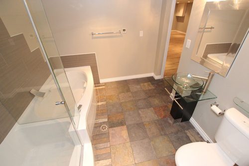 An overlooking view of a bathroom renovation project with new flooring and a tiled wall