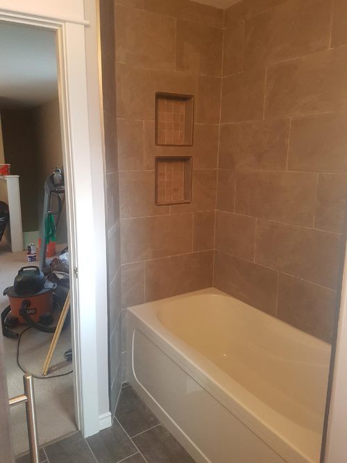 A bathroom renovation with decorative tiles and flooring to match