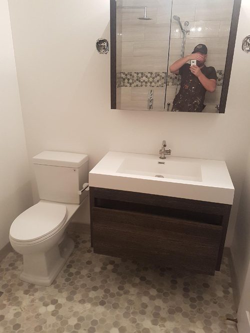 A decorative tile flooring and a very modern sink for a bathroom renovation project