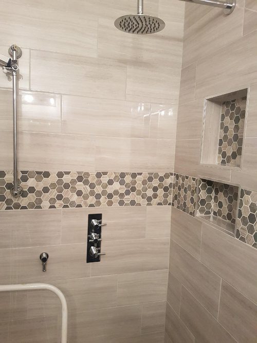 A decorative tile pattern and a modern showerhead for a bathroom renovation project