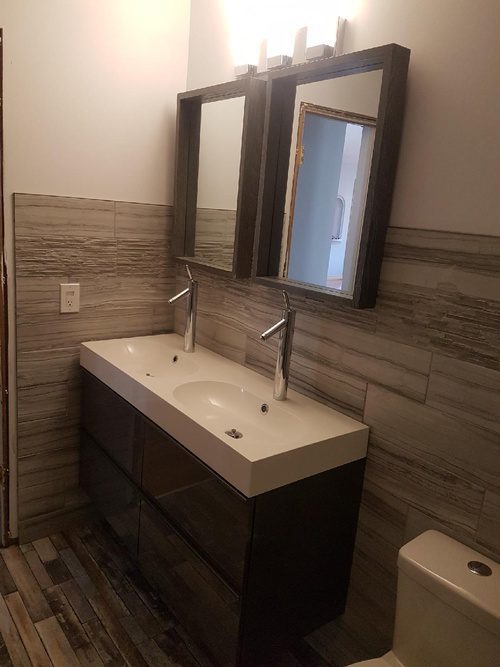 Dual mirrors and sinks for a wood-themed bathroom renovation