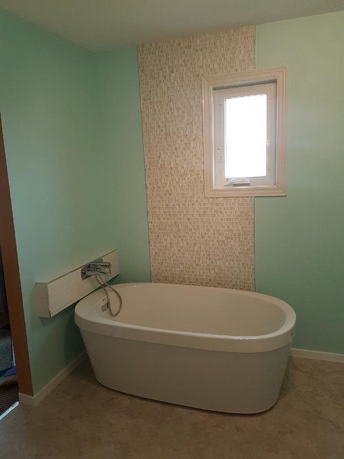 A decorative wall and a bathtub for a sea-themed bathroom renovation