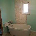 A decorative wall and a bathtub for a sea-themed bathroom renovation - Bathroom Renovations Winnipeg - Dash Builders