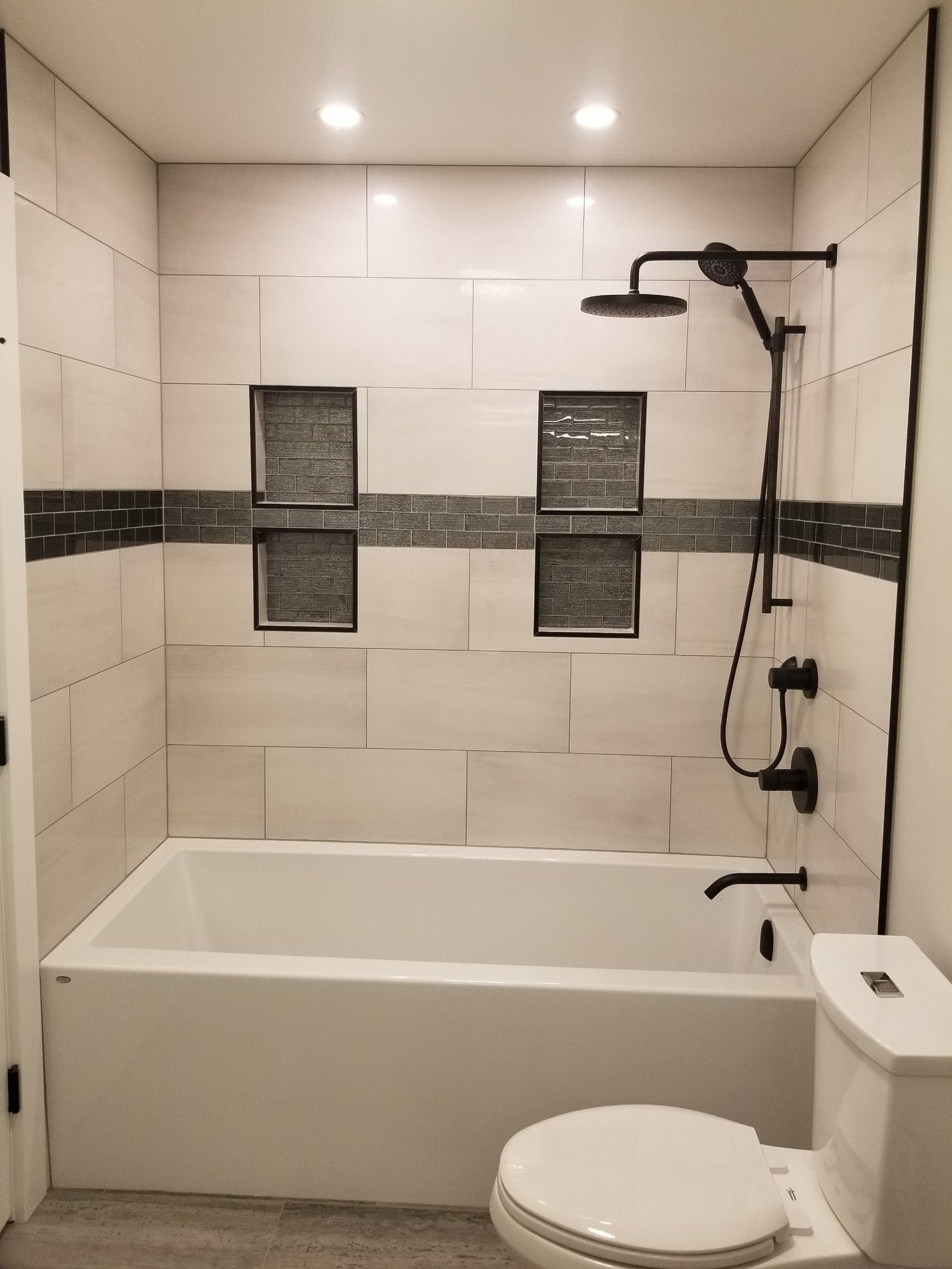 modern bathtub renovation black hardware rain shower